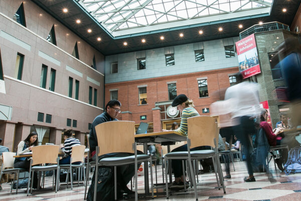 People sit at tables working in Sage atrium.