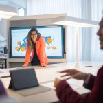 Corporate team engaged in a lively discussion around a digital presentation, fostering collaboration and innovation.
